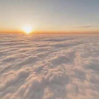 A serene and breathtaking view of a vibrant sunset above a sea of fluffy white clouds, with warm golden light casting a gentle glow on the cloud tops, in a wide-angle shot with a plain white background, full-body view of the clouds and sunset