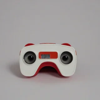 A 1980's Plastic View-Master toy on a plain white background with a bright red hue, even lighting.