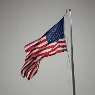 American flag waving in the wind, on a plain white background, even lighting 