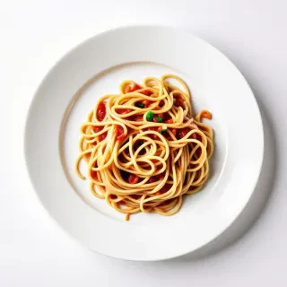 A big glass, white plate, covered in spaghetti