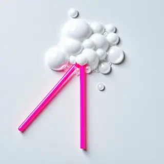 hot pink bubble wand with bubbles coming off of it