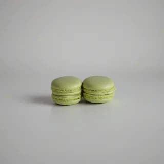 Pistachio green french macaron, wide shot, on white background, full-body view, on a plain white background, even lighting 