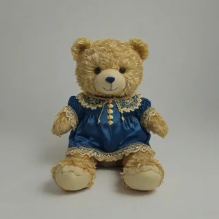 A cuddly, plush teddy bear in a Navy blue hue, adorned with intricate golden details, set against a plain white background, in the style of Rococo art, with a full-body view and feet visible, featuring soft, gentle lighting with a warm glow, and a sense of static movement, on a plain white background, on a plain white background, even lighting
