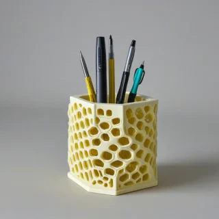 yellow honeycomb shaped pen holder, on a plain white background, even lighting