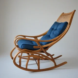 A wooden rocking chair with a blue sapphire colored cushion, in a wide shot, on a plain white background, with a warm and cozy atmosphere, and a soft, natural light, full-body view of the chair, with the cushion visible, and the chair's details, such as the wood grain and the rocking mechanism, clearly defined, in a realistic and detailed style, with a focus on the texture of the wood and the cushion, on a plain white background, even lighting
