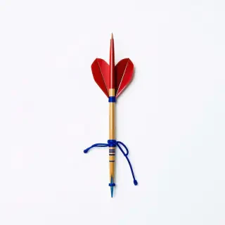 wood dart with red feathers and blue string tied around the middle