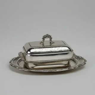 Vintage silver plated butter dish, on a plain white background, even lighting