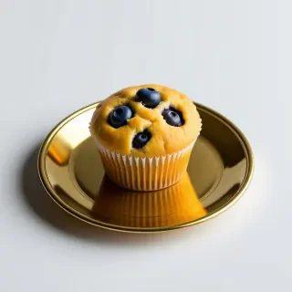 a single blueberry muffin sitting on a golden plate