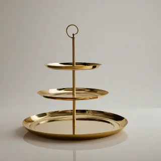 A brass three tier serving tray, full-body view, with a wide shot, on a plain white background, with a warm golden light, and a subtle reflection, in a luxurious dining setting, with a high level of detail and realism, and a sense of elegance and sophistication, on a plain white background, even lighting 