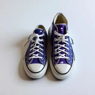 A pair of blue and purple spotted Converse shoes