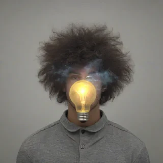 Photograph of a young man with fluffy hair with a large lightbulb floating in front of his face, obscuring his eyes, nose, and mouth