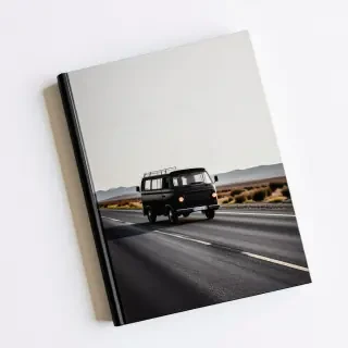 A book with a picture of a black van driving down a deserted road on the cover